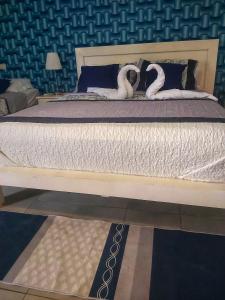 a bed with two white swans on it at Punta Cana Blue Beach Estudio in Punta Cana
