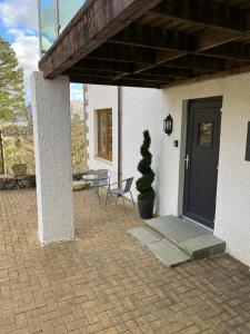 a patio with a door and a table and chairs at Tigh Stobban Apartment 1 in Fort William