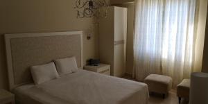 a bedroom with a white bed and a window at gold city alanya appartement in Kargicak +28 photos