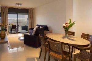 - un salon avec une table et un canapé dans l'établissement Apartaments Terraza - Salatà Mar, à Roses
