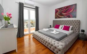 a bedroom with a large bed with pink pillows at GKK House private swimming pool luxury house in Skriperón