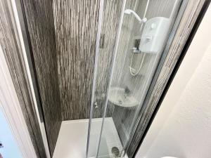Un baño con ducha, inodoro y lavabo. en Beaconsfield Holiday Apartments, en Bridlington 175 fotos más