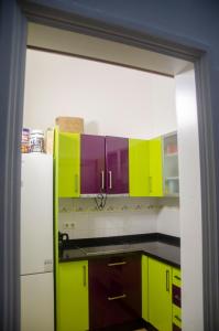 a kitchen with green and purple cabinets and a refrigerator at The Wave Temple in Las Palmas de Gran Canaria