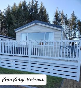 uma cerca branca em frente a uma pequena casa em Pine Ridge Retreat With FREE GOLF and Air Conditioning em Morpeth