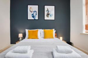 um quarto com uma cama grande e almofadas laranja em Stylish 2 Bedroom Flat - Close To Newcastle City Centre em Gateshead