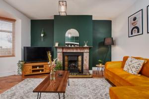 a living room with a couch and a fireplace at Stylish 2 Bedroom Flat - Close To Newcastle City Centre in Gateshead