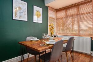 uma sala de jantar com uma mesa de madeira e cadeiras em Stylish 2 Bedroom Flat - Close To Newcastle City Centre em Gateshead