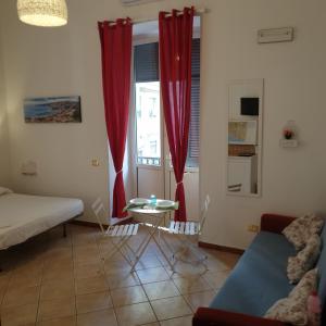 soggiorno con tende rosse e tavolo di Sweet Home a Napoli