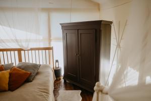 a bedroom with a bed and a wooden cabinet at Dunduriņi in Talsi