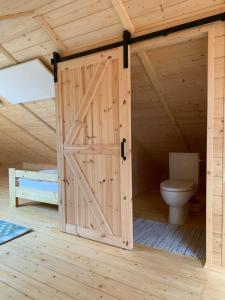 a wooden bathroom with a toilet in a wooden house at Dom Wanoga Małe Swornegacie in Małe Swornegacie