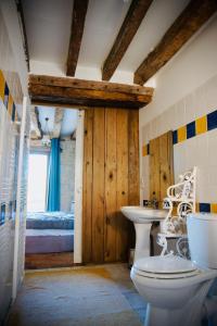 a bathroom with a toilet and a sink and a bed at Studio campagne in Mézeray