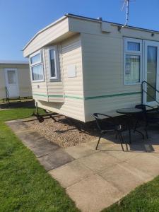 a tiny house with a table and a patio at The Topaz Caravan HF12 in Ingoldmells