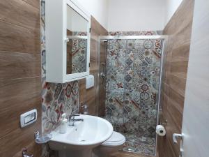 um banheiro com vaso sanitário, pia e chuveiro em Santorini house em San Pietro in Bevagna mais 20 fotografias