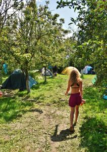 Eine Frau, die mit einem Regenschirm auf einer unbefestigten Straße läuft. in der Unterkunft Secret Garden Camping in Bontida