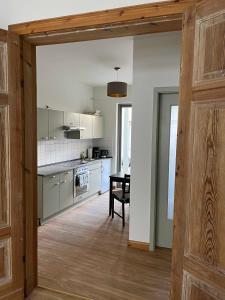 a kitchen with a wooden door leading to a dining room at Im Zentrum wohnen, Ruhe genießen in Greifswald