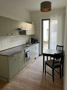 a kitchen with a table and a table and a chair at Im Zentrum wohnen, Ruhe genießen in Greifswald