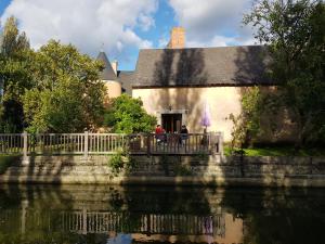 two people standing on a bridge in front of a building at Studio campagne in Mézeray