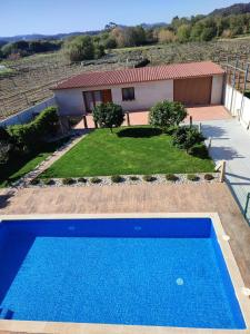a blue swimming pool in front of a house at Casa acogedora Mar de Albariño con Piscina in Cambados +11 photos