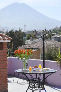 einen Tisch mit einer Blumenvase auf dem Balkon in der Unterkunft Casa Arequipa in Arequipa