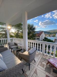 a porch with chairs and a table on a balcony at Villa Danijela with heated pool,jacuzzi and sauna in Seget Vranjica