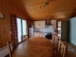Bellefontaine的住宿－Le repaire du Lynx，厨房配有木桌和木制天花板
