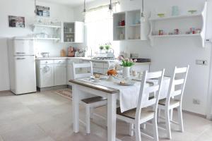 een witte keuken met een witte tafel en stoelen bij Charme Ibleo - Casa di campagna in Sicilia in Ragusa