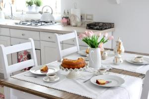 een witte keuken met een tafel met gebak erop bij Charme Ibleo - Casa di campagna in Sicilia in Ragusa