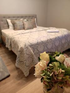 1 dormitorio con 1 cama con flores en el suelo en MAGIC LUX APARTAMENT HUNEDOARA, en Hunedoara