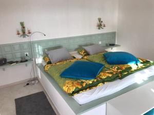 uma cama grande com almofadas azuis num quarto em Paz del Mar em Charco del Palo