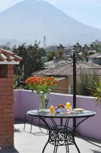 una mesa con un jarrón de flores en un patio en Casa Arequipa, en Arequipa