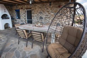 un patio con mesa, sillas y un columpio en Crystal Villa 4, en Chrissi Akti