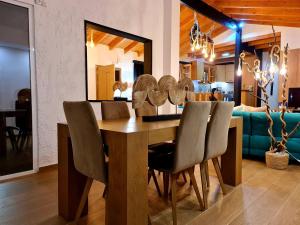 uma sala de jantar com uma mesa de madeira e cadeiras em Villa Gala em Balíon