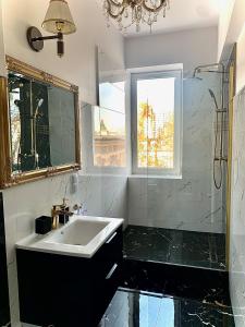 a bathroom with a sink and a shower and a mirror at KORONA Apartamenty Gdańsk in Gdańsk