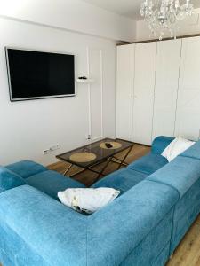 a blue couch in a living room with a tv at KORONA Apartamenty Gdańsk in Gdańsk