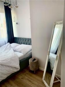 a small bedroom with a bed and a mirror at KORONA Apartamenty Gdańsk in Gdańsk