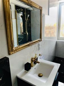 a bathroom with a white sink and a mirror at KORONA Apartamenty Gdańsk in Gdańsk
