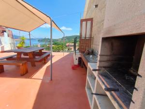 eine Terrasse mit einem Grill und einem Picknicktisch in der Unterkunft Casa Cabaleiro in Seixo