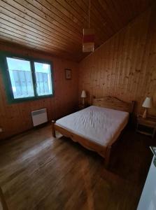 um quarto com uma cama grande num quarto de madeira em Le repaire du Lynx em Bellefontaine