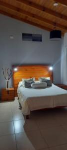 a bedroom with a large bed with a wooden headboard at Eljacaranda_ in Gualeguay