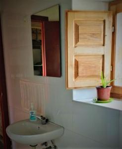 y baño con lavabo y espejo. en Albergue Tremaya, en Lebanza