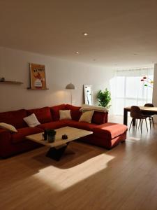 - un salon avec un canapé rouge et une table basse dans l'établissement Lac de maine - 75m2 refait a neuf, à Angers