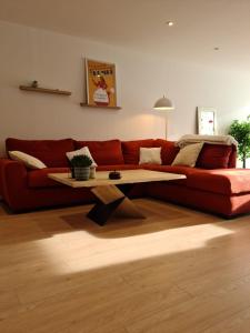 アンジェにあるLac de maine - 75m2 refait a neufのリビングルーム(赤いソファ、コーヒーテーブル付)