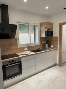 a kitchen with white cabinets and a stove top oven at Villa Renzo in Patrimonio