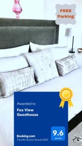 Cartel de una cama con almohadas blancas en Fox View Guesthouse en Bristol