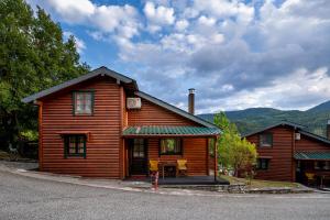 a wooden cabin with a table in front of it at Chalet Likouresi Village in Karpenisi