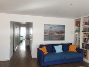 uma sala de estar com um sofá azul com almofadas laranja em Ferragial Central Apartament (DownTown) em Lisboa