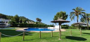 a swimming pool with umbrellas in a yard at Casa Alcasar in Benitachell