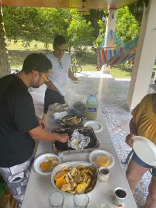 un grupo de hombres parados alrededor de una mesa con comida en Cabaña Kundalini, en Antón