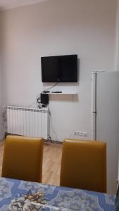 a room with two chairs and a tv on the wall at Zeynep Apartments in Sarajevo