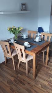 a dining room table with chairs and a wooden table with flowers at Fewo Kastel in Nonnweiler